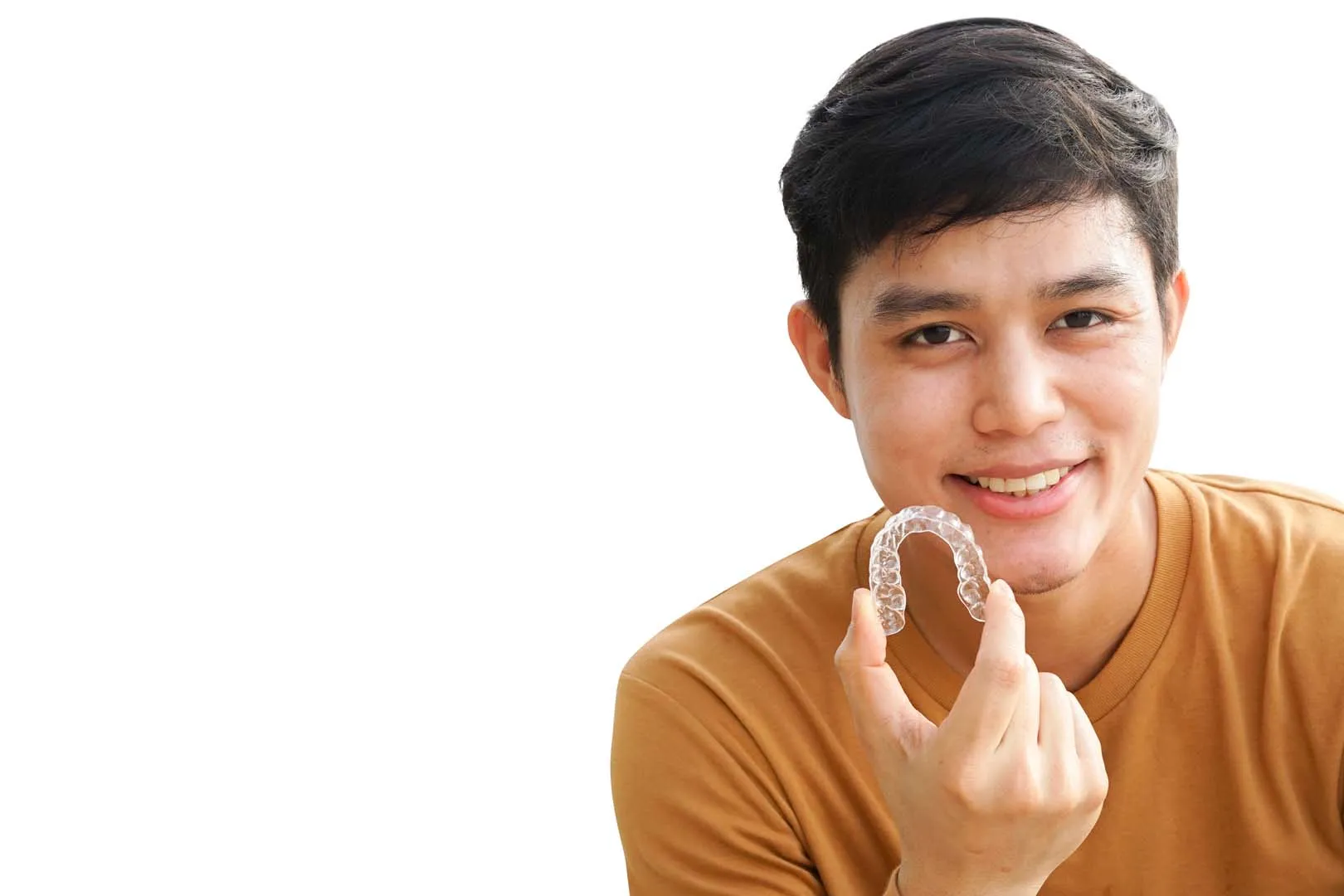Clear aligner tray next to traditional braces